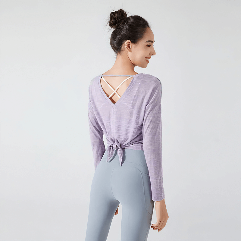 Woman wearing a lavender see-through back-cutout top for active wear, showcasing the trendy design and breathable fabric.